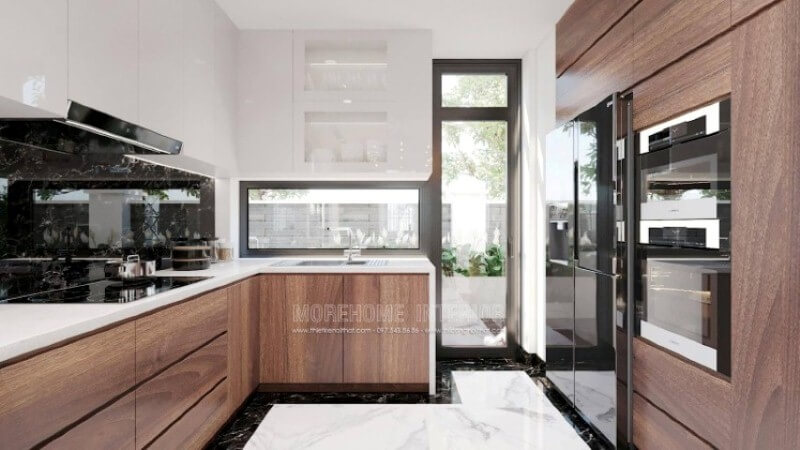 Là một trong những xu hướng thiết kế nội thất ấn tượng trong những năm tới, trang trí phòng bếp hiện đại tôn lên vẻ đẹp mộc mạc nhưng không kém phần sang trọng của gỗ điển hình là gỗ óc chó tự nhiên. Loại gỗ rất được ưa chuộng trong các siêu xe bởi vẻ đẹp ấn tượng từ vân, màu gỗ. Như trong ý tưởng trang trí phòng bếp tại biệt thự Vinhomes Imperia, sự hài hòa tôn lên nét đẹp giữa truyền thống và hiện đại, tủ bếp dưới gỗ óc chó veneer và tủ bếp trên acrylic trắng bóng. Tủ bếp gỗ công nghiệp và tủ bếp acrylic